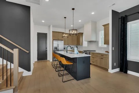 a kitchen with stainless steel appliances granite countertop a sink a stove and a refrigerator