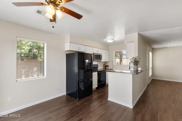 a kitchen with kitchen island white cabinets and stainless steel appliances