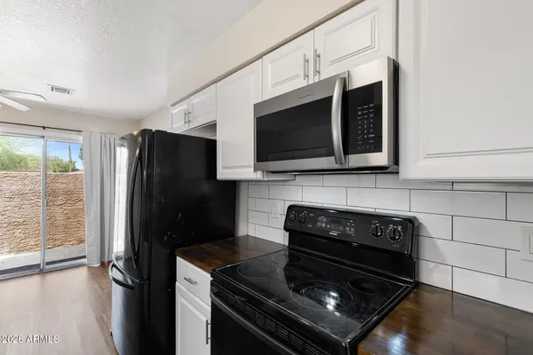 a kitchen with stainless steel appliances granite countertop a stove microwave and refrigerator