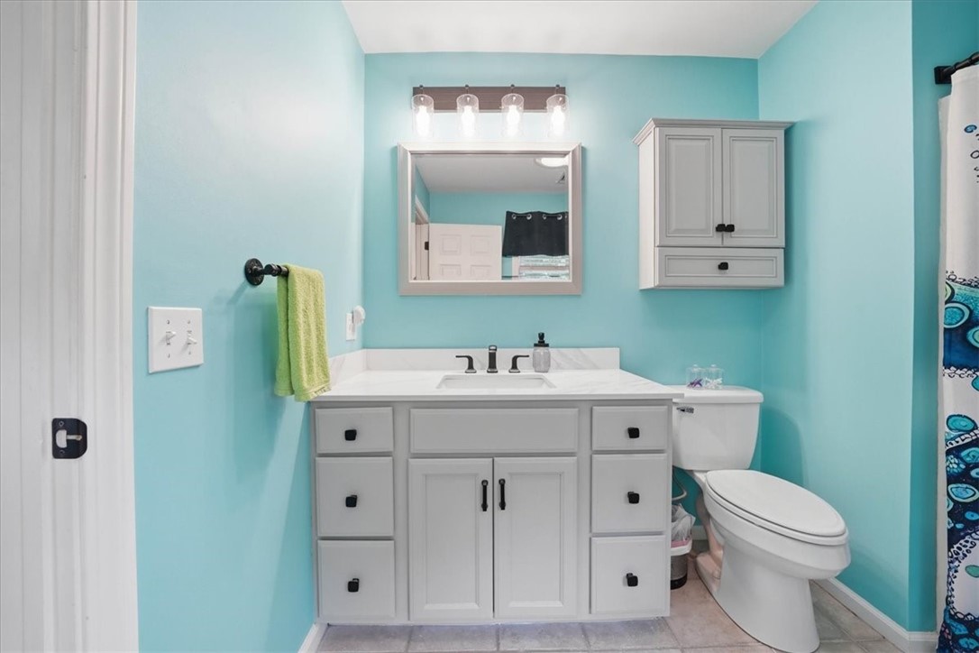26 Davis Circle Warwick, RI 02886 - Photo 33 of 50 The thoughtfully renovated primary bath blends timeless style with everyday functionality, offering a large furniture-style vanity with abundant storage, elegant solid-surface countertop, designer lighting, updated fixtures, tile flooring, and a spacious shower/tub combination.