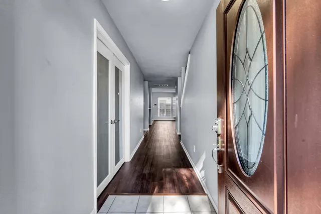 a view of a hallway with wooden floor and staircase