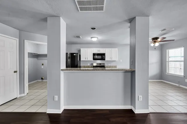 a view of kitchen with stainless steel appliances refrigerator stove microwave and cabinets