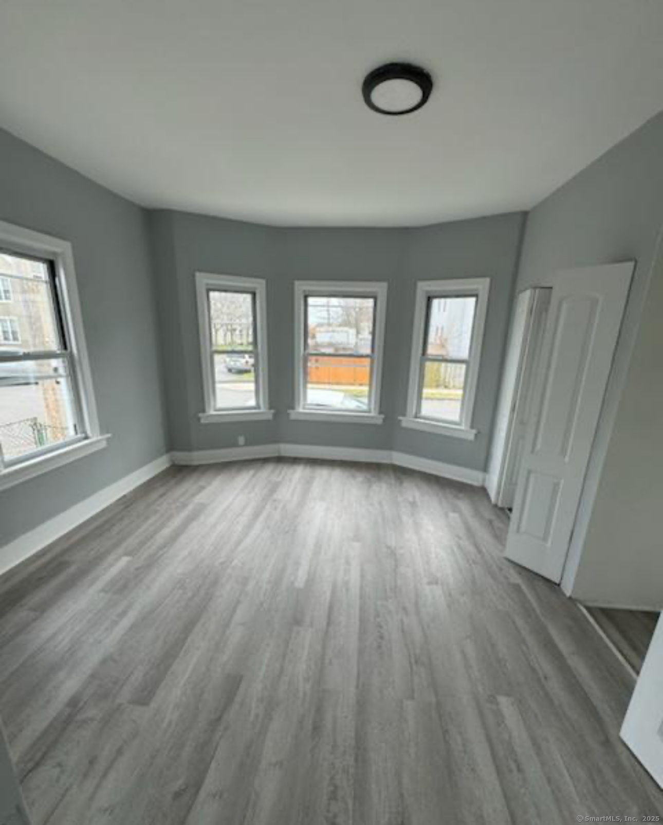 655 Maple Street, Unit 2 Bridgeport, CT 06608 - Photo 3 of 4 a view of an empty room with wooden floor and window