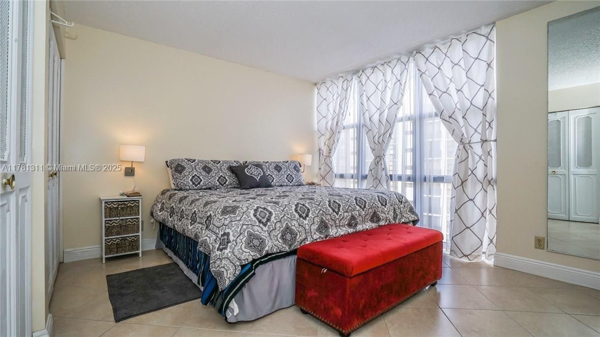 17011 North Bay Road, Unit 701 Sunny Isles Beach, FL 33160 - Photo 12 of 41 a bedroom with a bed and wooden floor
