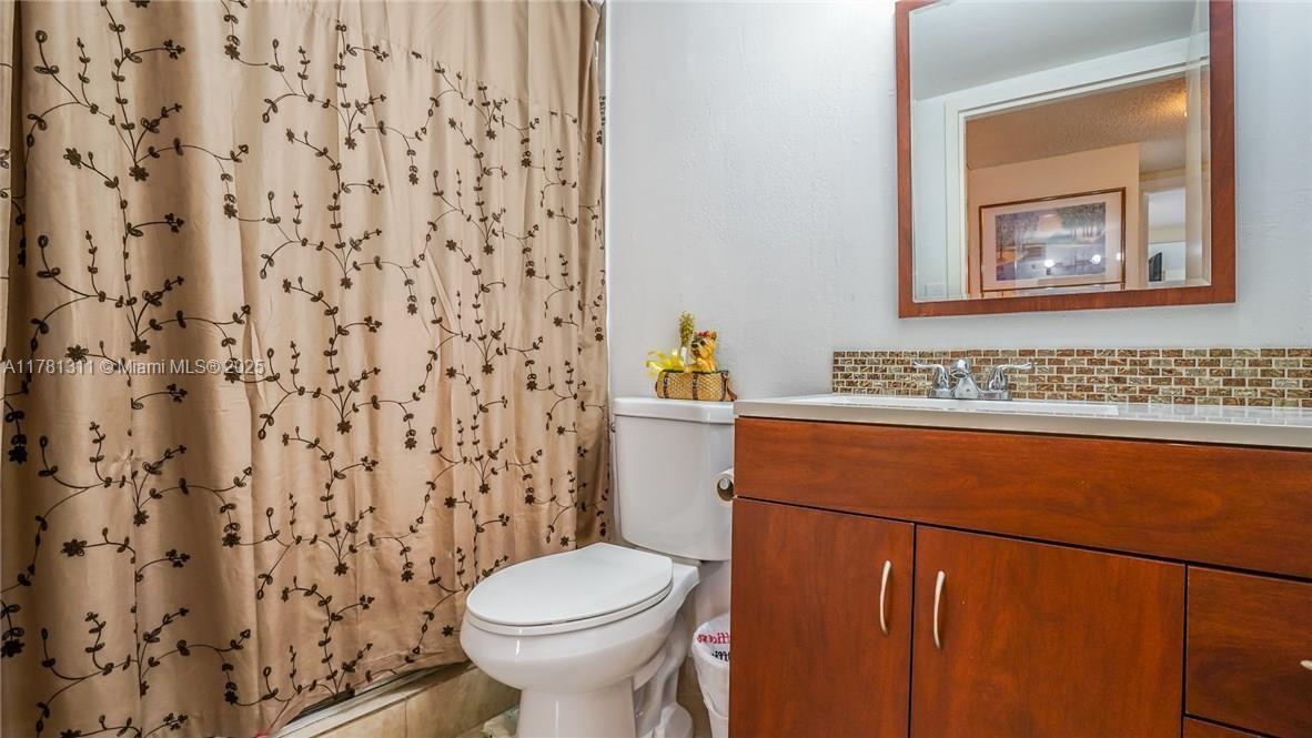 17011 North Bay Road, Unit 701 Sunny Isles Beach, FL 33160 - Photo 16 of 41 a bathroom with a toilet and a shower curtain