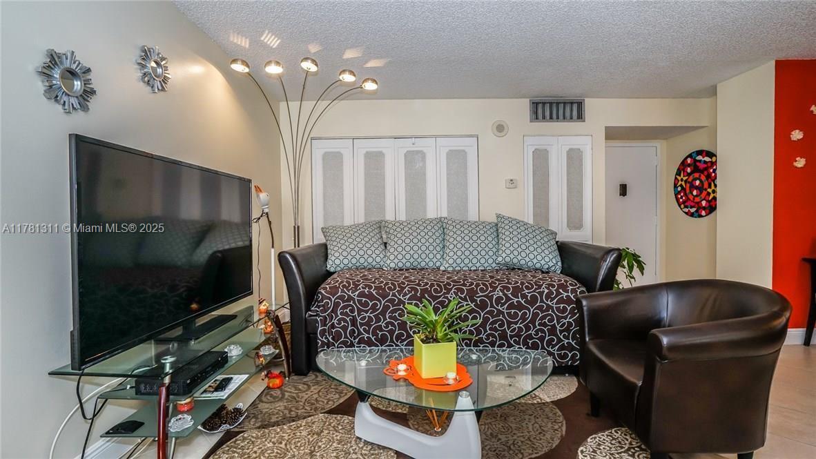 17011 North Bay Road, Unit 701 Sunny Isles Beach, FL 33160 - Photo 2 of 41 a living room with furniture and a flat screen tv