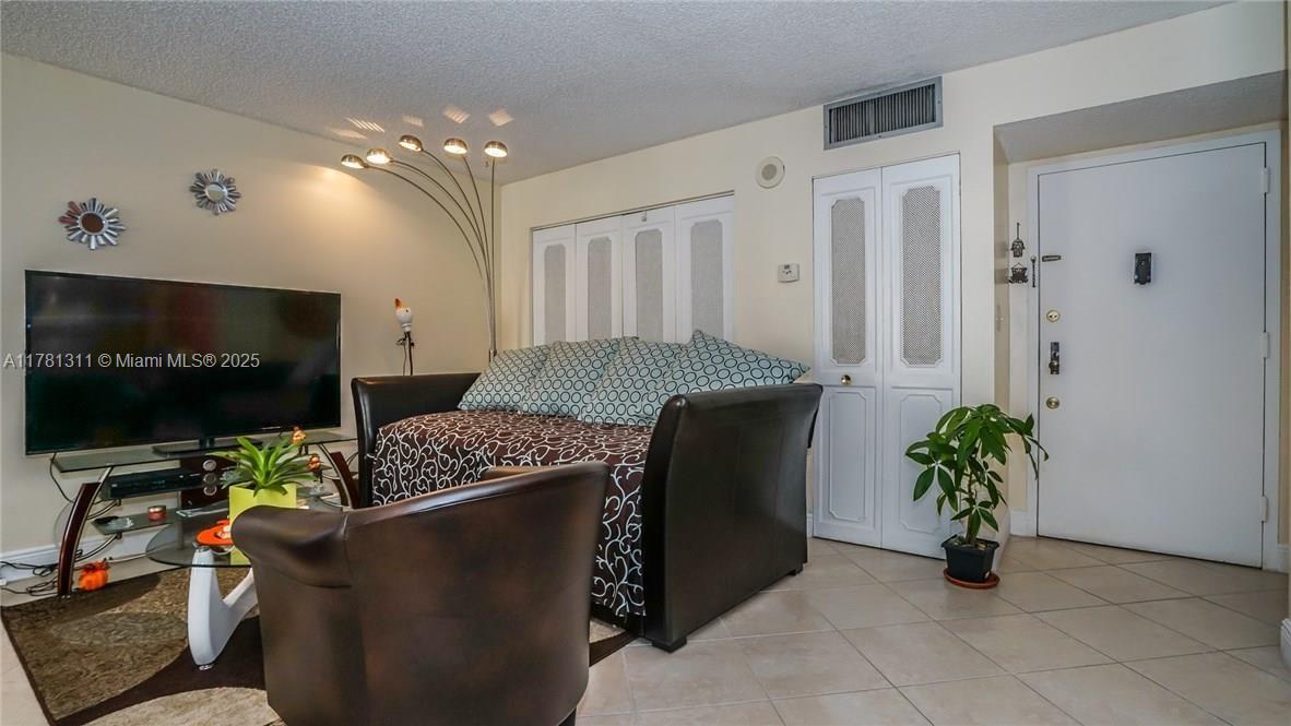 17011 North Bay Road, Unit 701 Sunny Isles Beach, FL 33160 - Photo 3 of 41 a living room with furniture and a flat screen tv