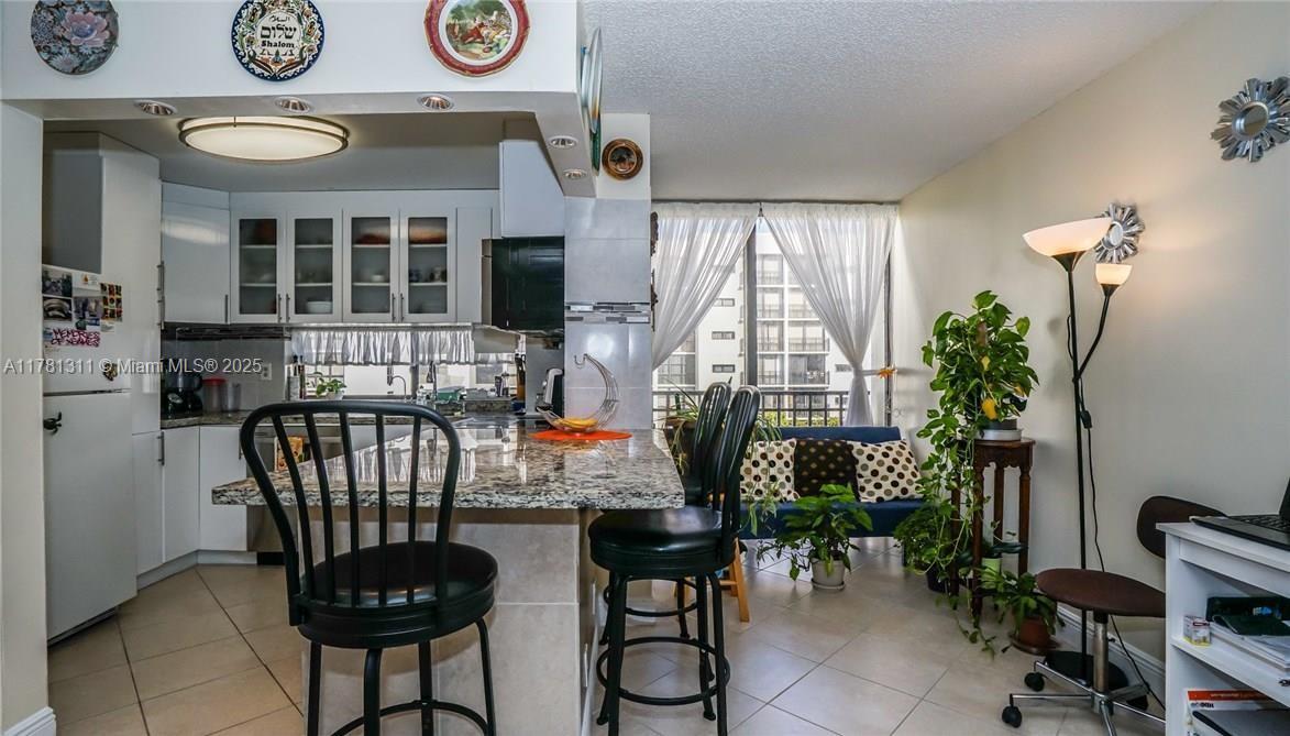 17011 North Bay Road, Unit 701 Sunny Isles Beach, FL 33160 - Photo 5 of 41 a table with chairs in front of a window
