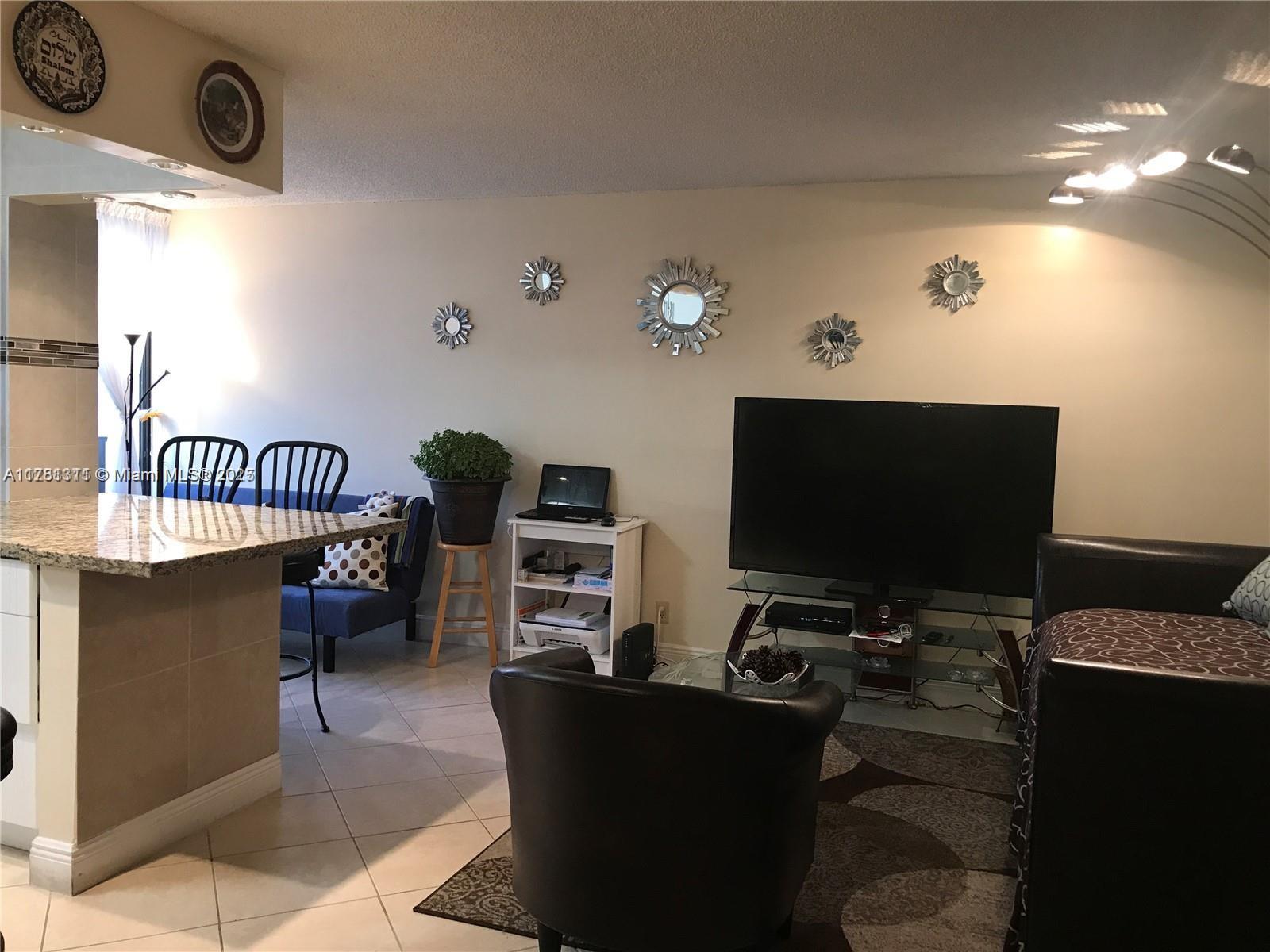 17011 North Bay Road, Unit 701 Sunny Isles Beach, FL 33160 - Photo 7 of 41 a living room with furniture and a flat screen tv