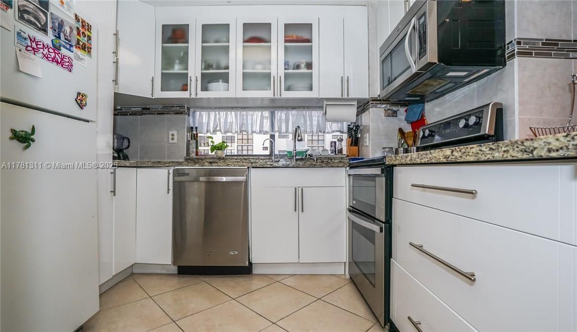 17011 North Bay Road, Unit 701 Sunny Isles Beach, FL 33160 - Photo 9 of 41 a kitchen with stainless steel appliances granite countertop a refrigerator and a stove