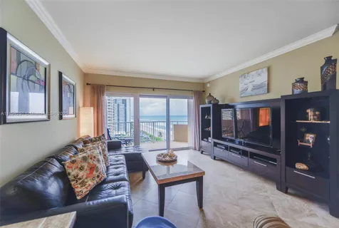 a living room with furniture a bookshelf and a flat screen tv