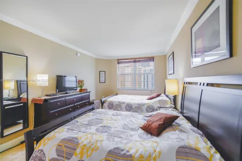 a bedroom with two beds and a flat screen tv