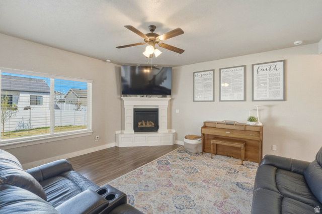 836 South 250 West Vernal, UT 84078 - Photo 21 of 56 Living room featuring wood finished floors, a ceiling fan, and a glass covered fireplace