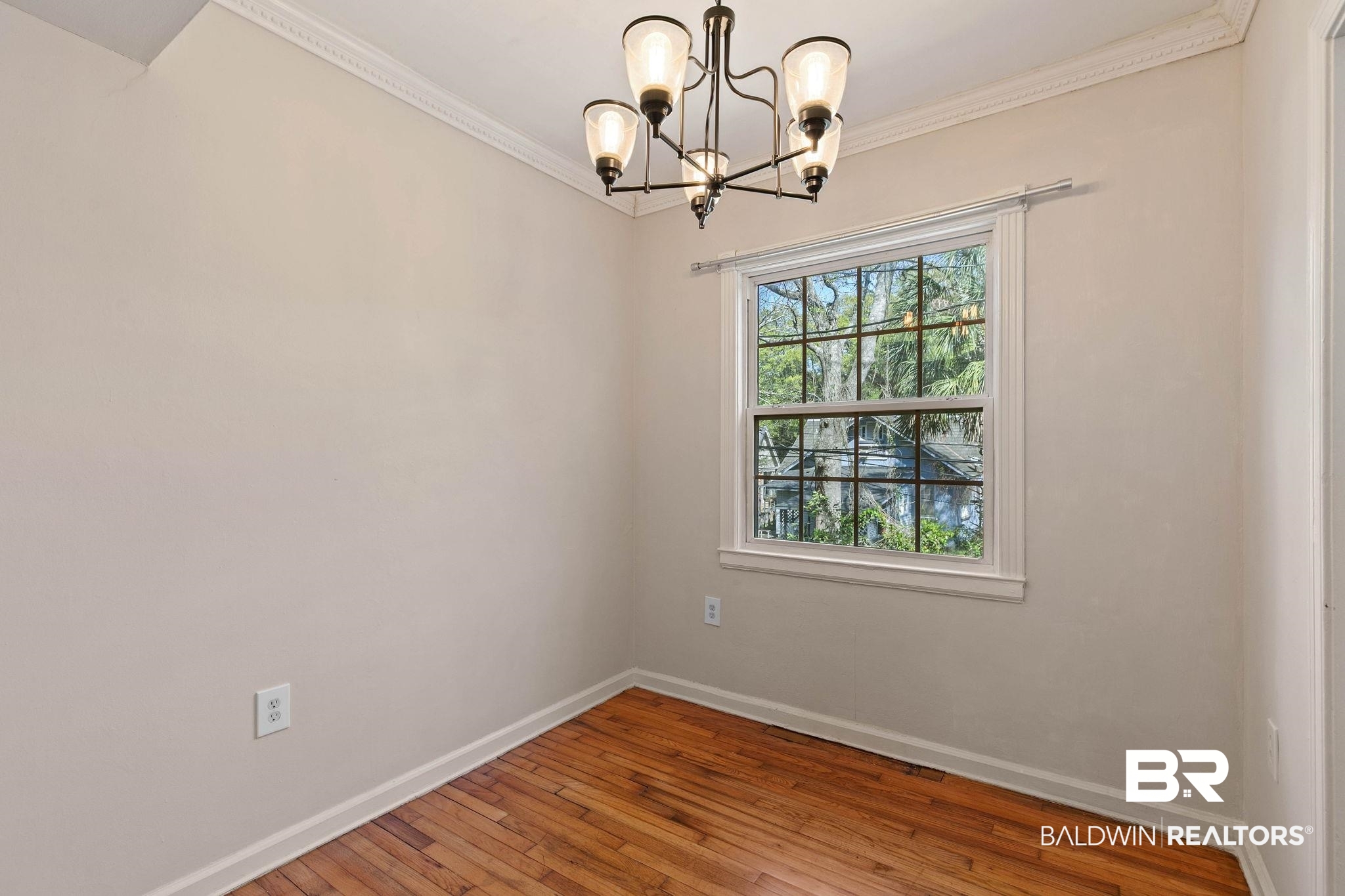 214 Upham Street, Unit 8D Mobile, AL 36607 - Photo 17 of 36 Spare room with hardwood / wood-style floors, hanging lights, and crown molding