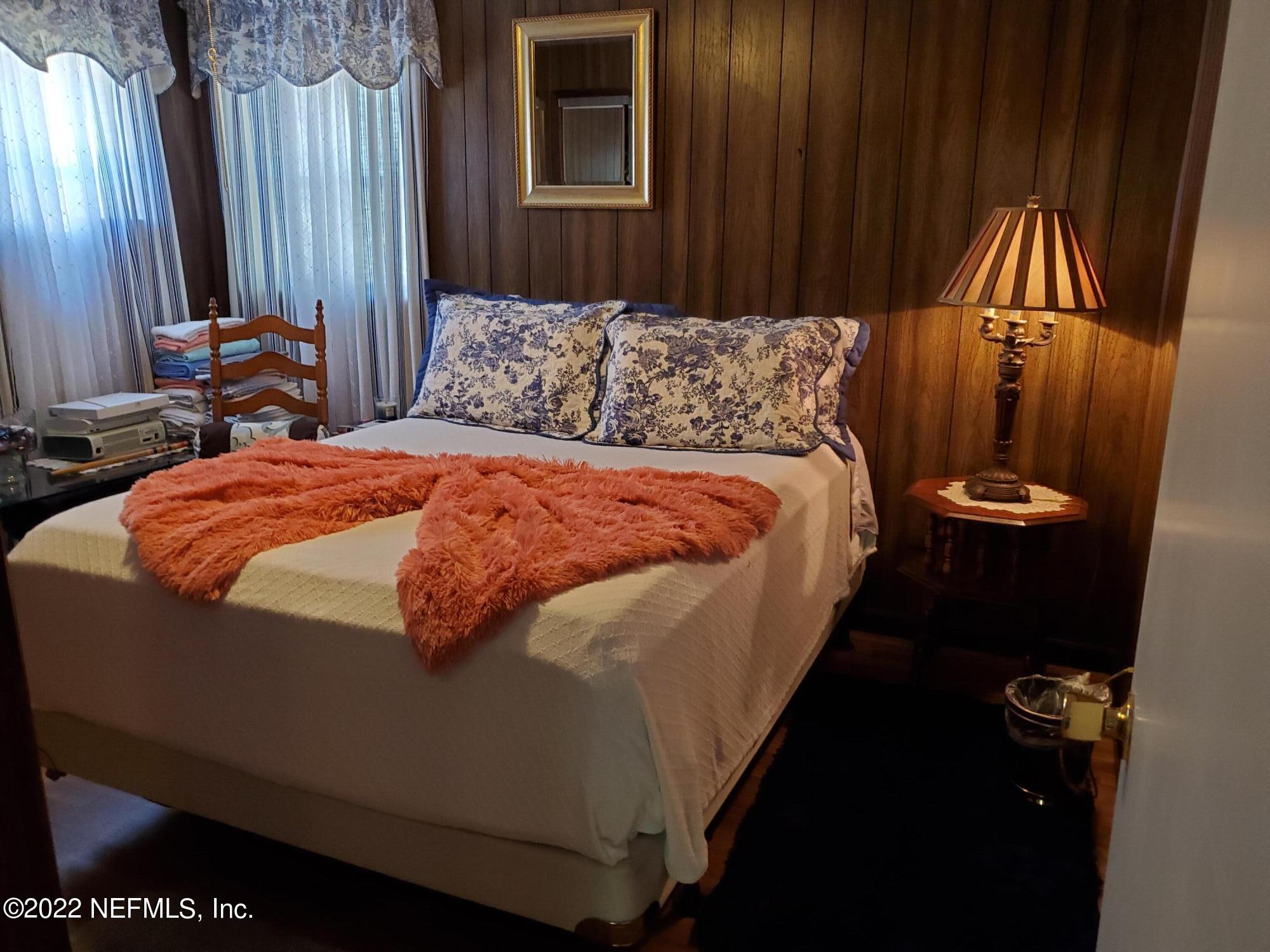 106 Comer Road Palatka, FL 32177 - Photo 15 of 19 a bed sitting in a bedroom next to a wooden door