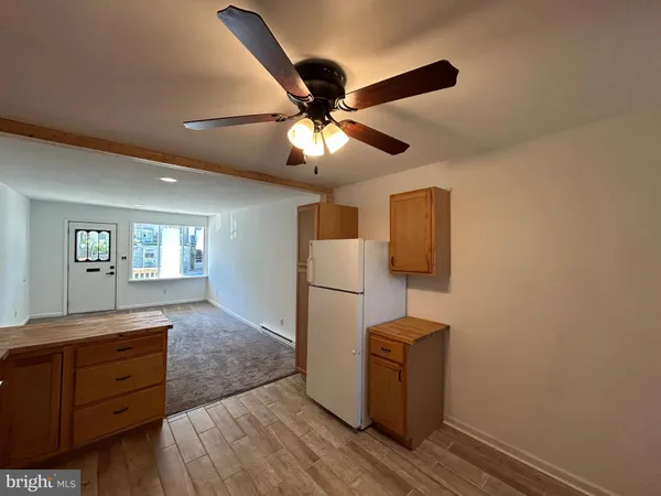a kitchen that has a microwave and wooden floor