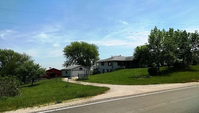 10009 Center Road Durand, IL 61024 - Photo 1 of 25 a house with green field in front of it