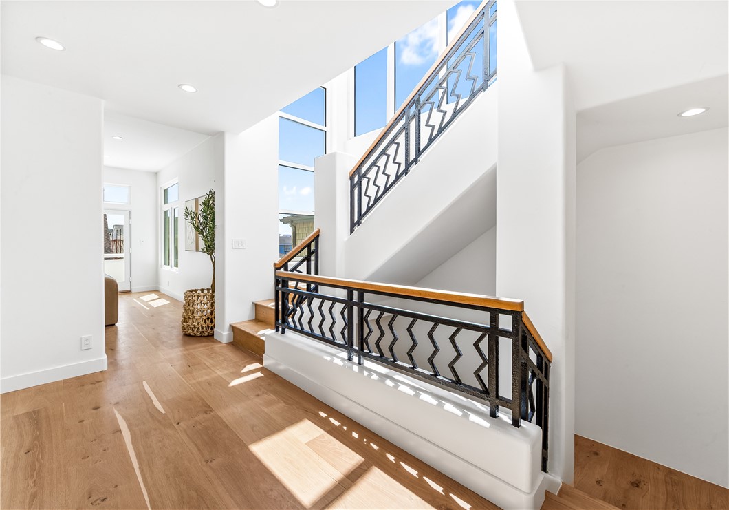 541 4th Street Manhattan Beach, CA 90266 - Photo 37 of 45 a view of staircase with white walls and a lots of frames on wall