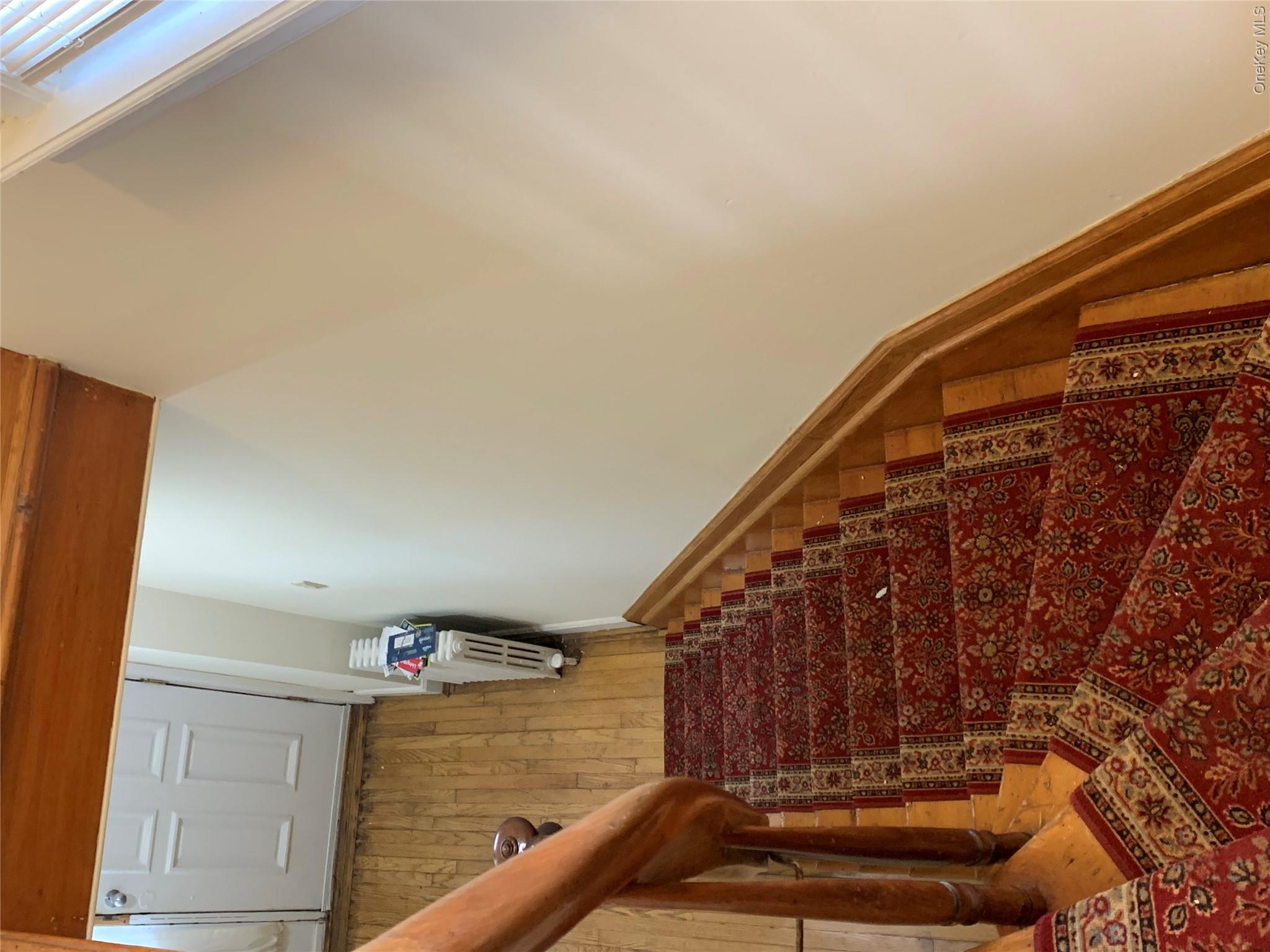7 Clinton Street Haverstraw, NY 10927 - Photo 10 of 20 Wood-finish staircase with a red patterned runner and polished wood handrail