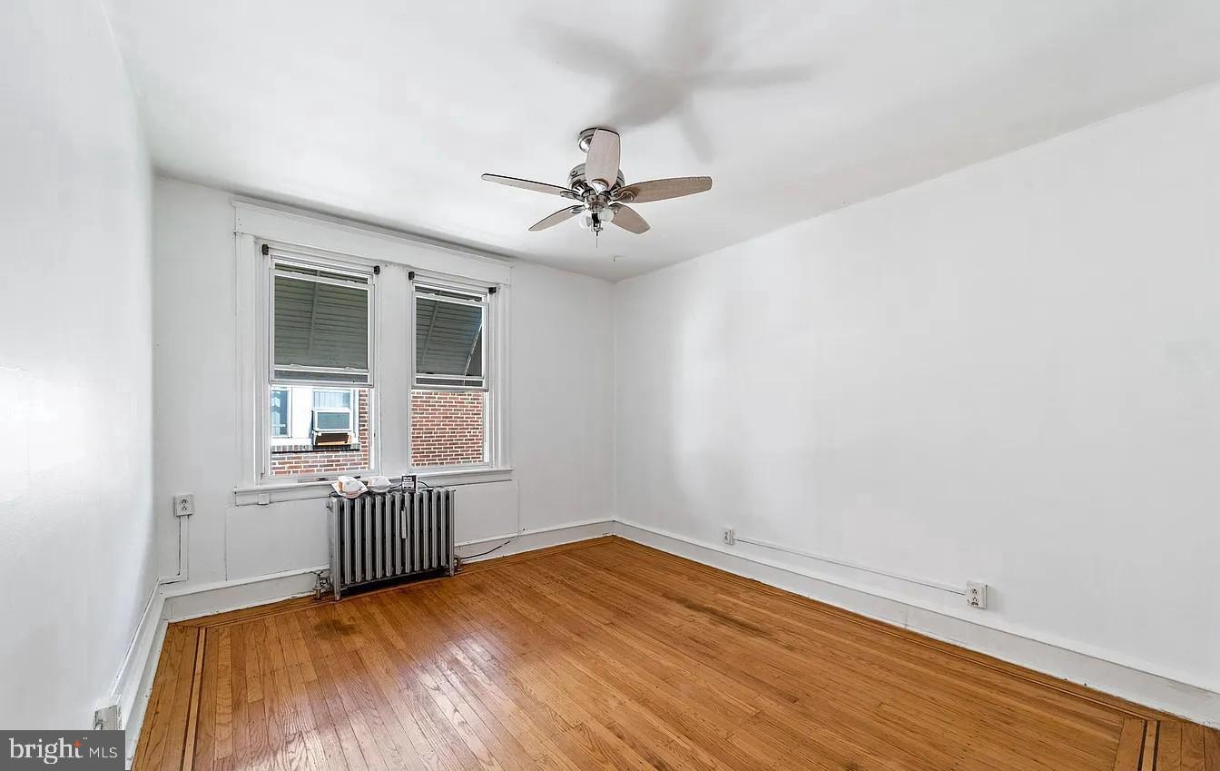 2329 Rhawn Street Philadelphia, PA 19152 - Photo 22 of 23 an empty room with wooden floor chandelier fan and windows
