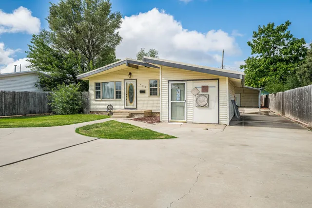 a front view of a house with a yard and potted plants