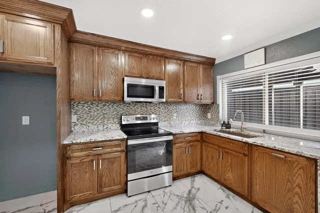 a kitchen with stainless steel appliances granite countertop a sink stove microwave and cabinets