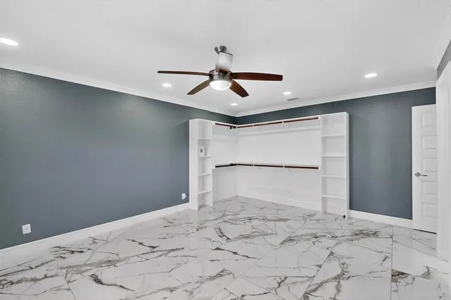 a room with a ceiling fan and a rug