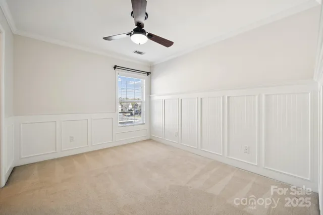 an empty room with chandelier fan