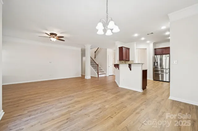 a view of a kitchen with wooden floor and a chandelier