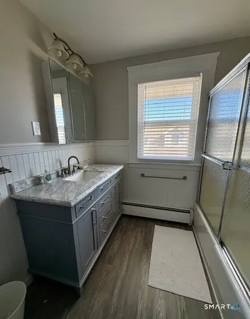 a bathroom with a granite countertop sink mirror vanity and a bathtub