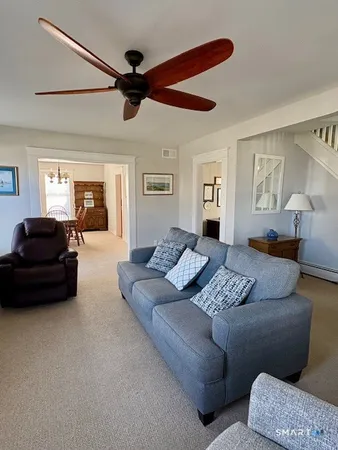 a living room with furniture and a ceiling fan