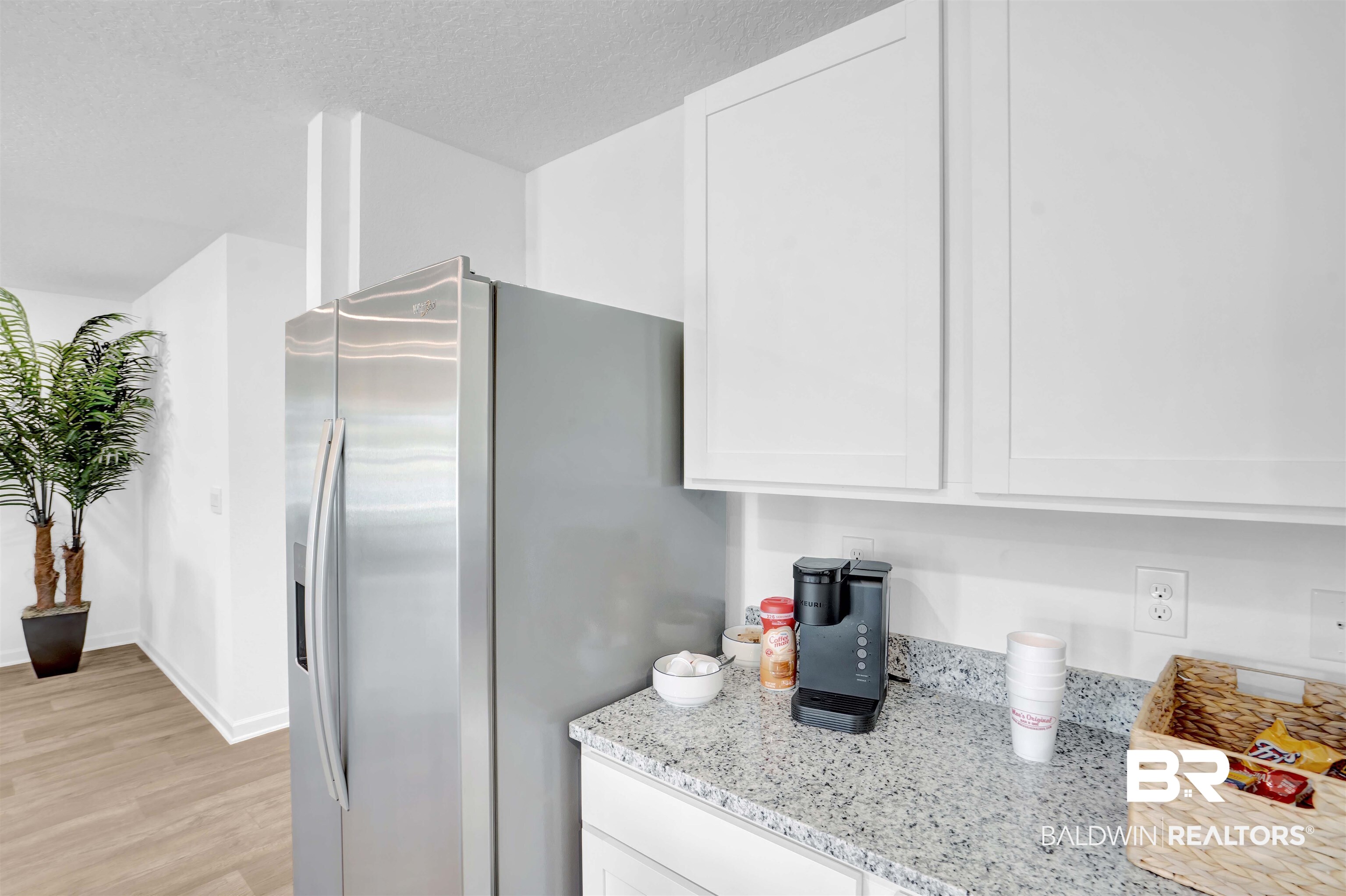 14717 Dayton Circle Foley, AL 36535 - Photo 16 of 39 Kitchen featuring white cabinetry, light stone countertops, stainless steel fridge, a textured ceiling, and light wood-type flooring