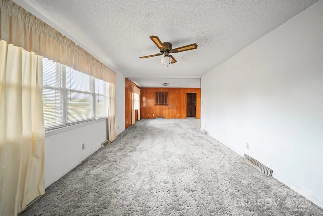 a view of a livingroom with a ceiling fan and window