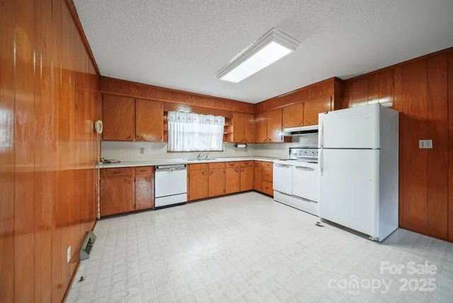 a view of kitchen with refrigerator and cabinets