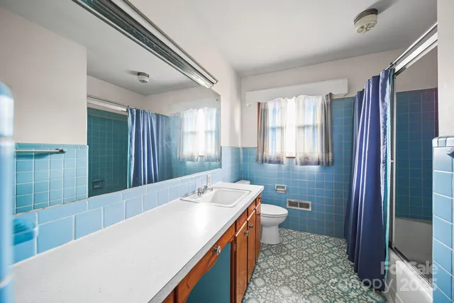 a front view of a house with basket ball court and glass windows