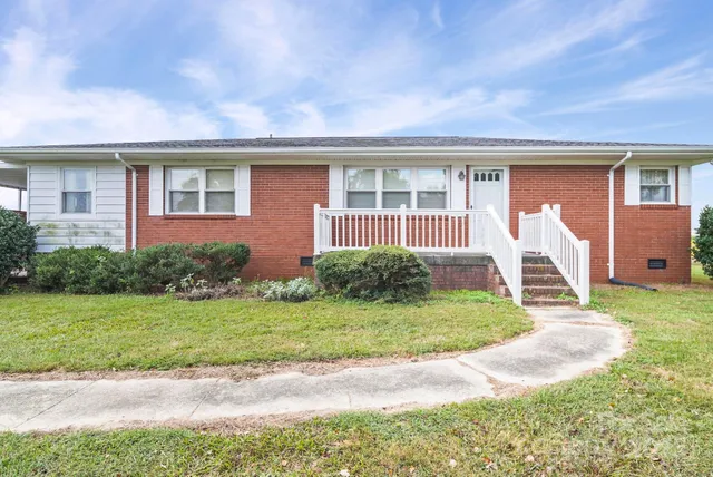 a front view of a house with a yard and seating space