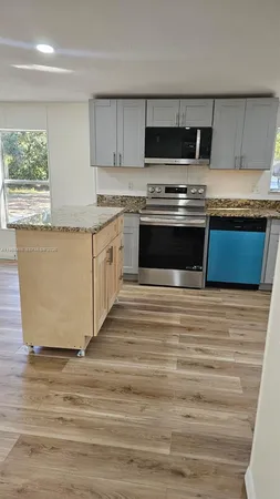 a kitchen with stainless steel appliances granite countertop a stove a sink and a refrigerator