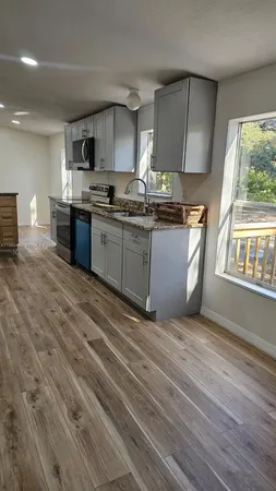 a view of kitchen with wooden floor refrigerator and window