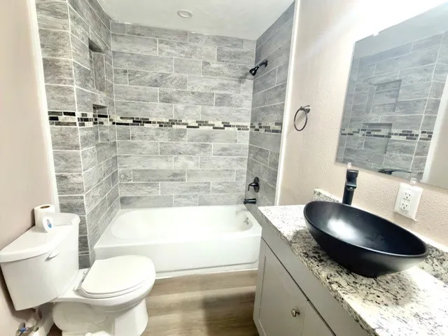 a bathroom with a granite countertop toilet sink and shower