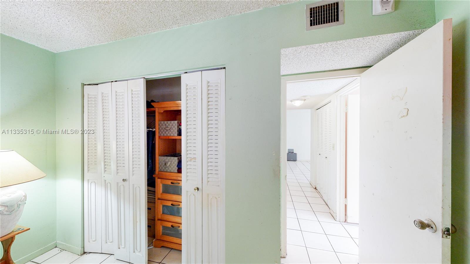 1750 West 46th Street, Unit 312 Hialeah, FL 33012 - Photo 20 of 41 a view of a hallway with wooden cabinets and entryway