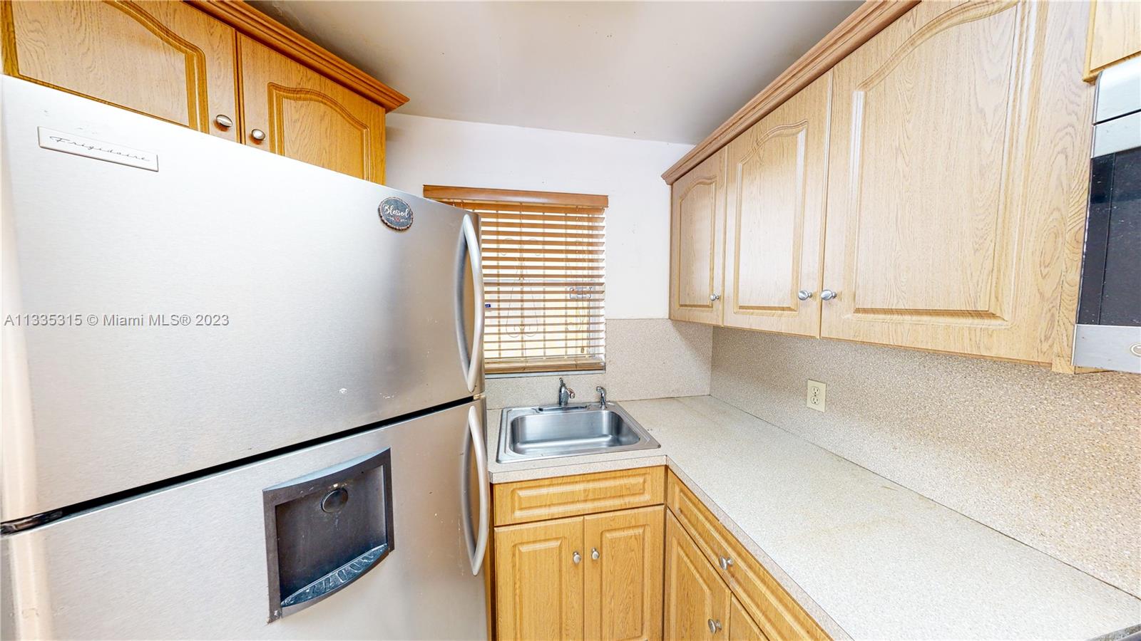 1750 West 46th Street, Unit 312 Hialeah, FL 33012 - Photo 9 of 41 a kitchen with stainless steel appliances a refrigerator sink and cabinets