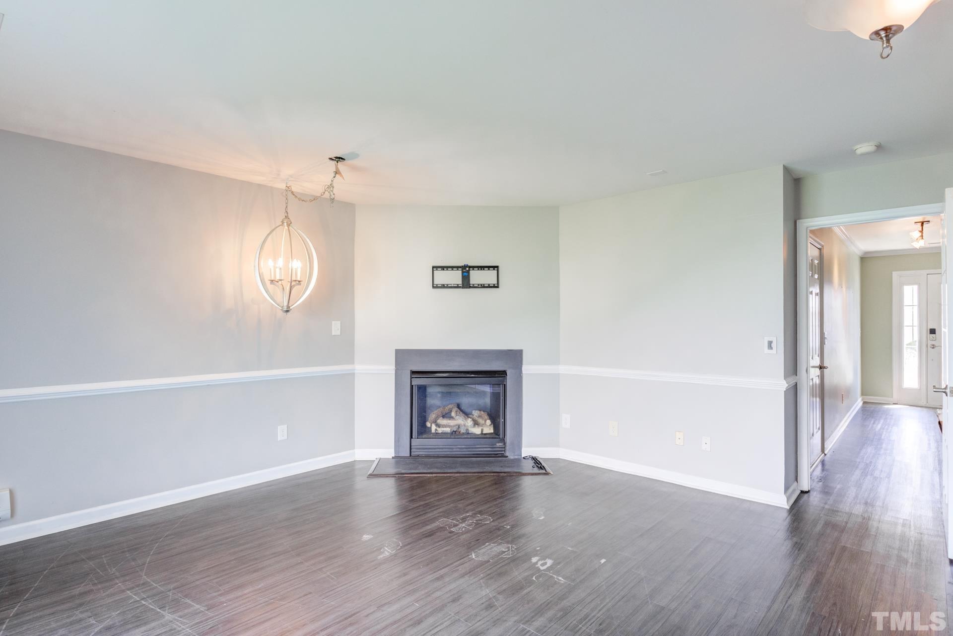 4911 Midstone Lane Raleigh, NC 27610 - Photo 11 of 28 a view of an empty room with wooden floor fireplace and a window