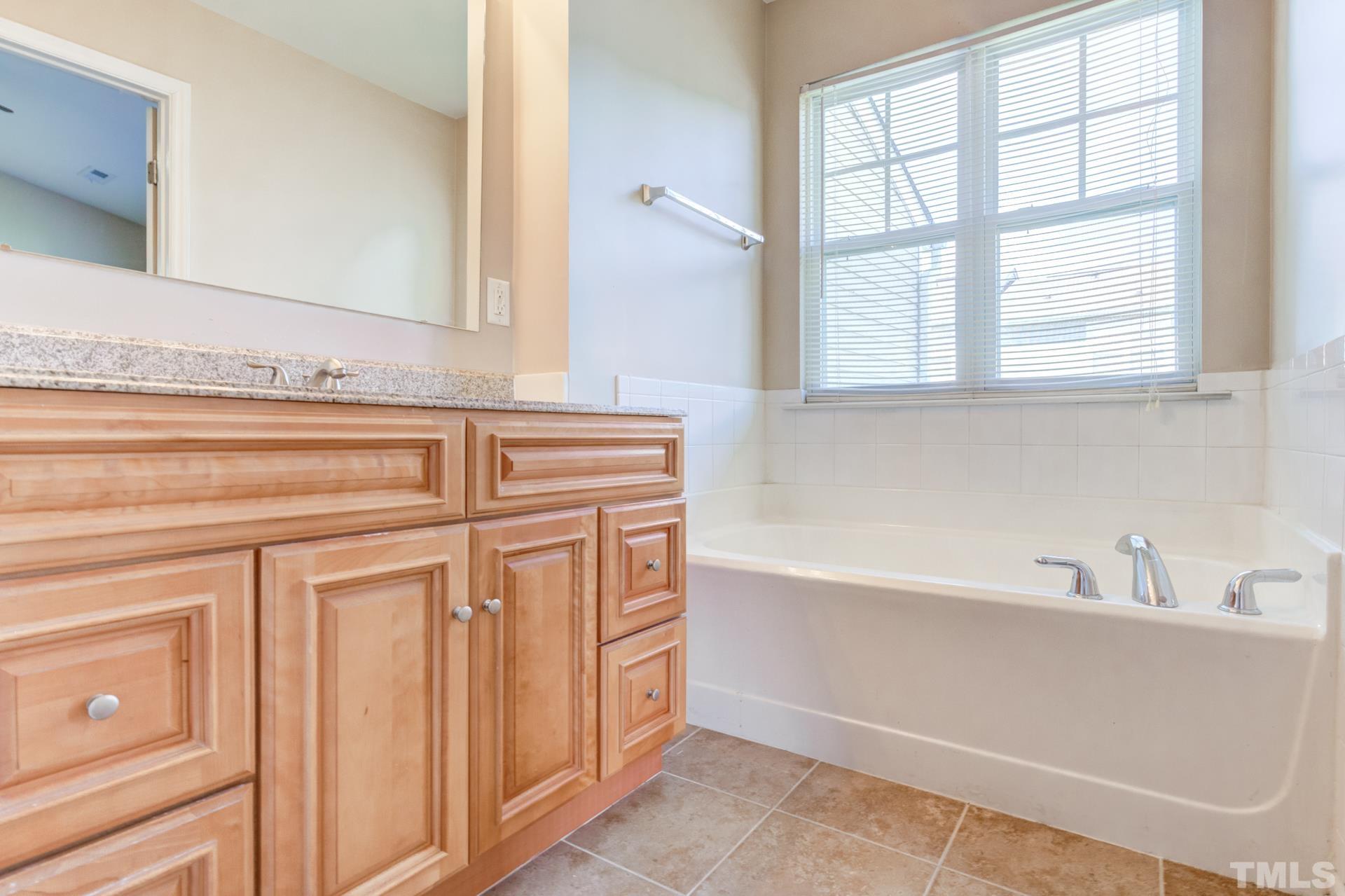 4911 Midstone Lane Raleigh, NC 27610 - Photo 23 of 28 a bathroom with a bathtub and a sink