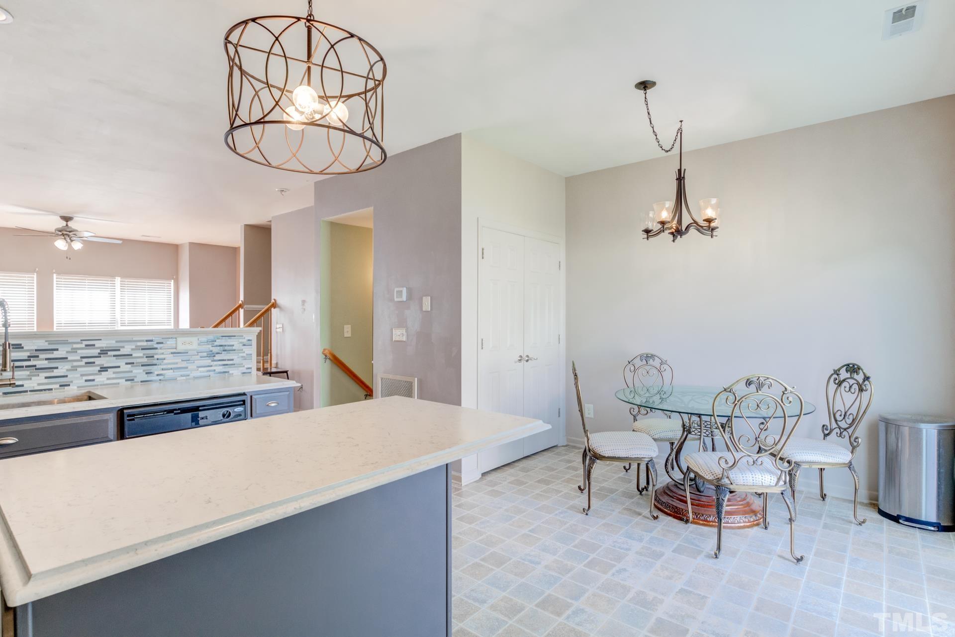 4911 Midstone Lane Raleigh, NC 27610 - Photo 28 of 28 a dining room with wooden table chairs and chandelier