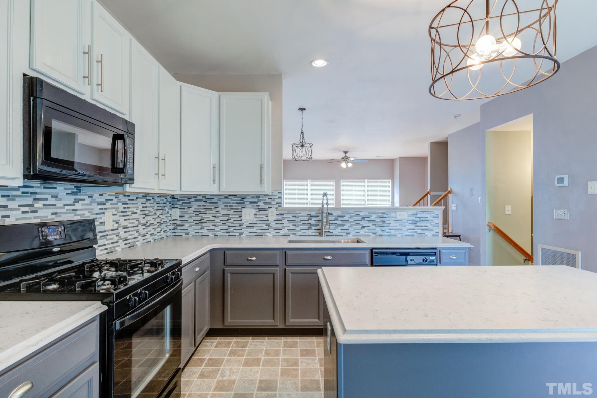 4911 Midstone Lane Raleigh, NC 27610 - Photo 6 of 28 a kitchen with stainless steel appliances granite countertop a sink stove and microwave