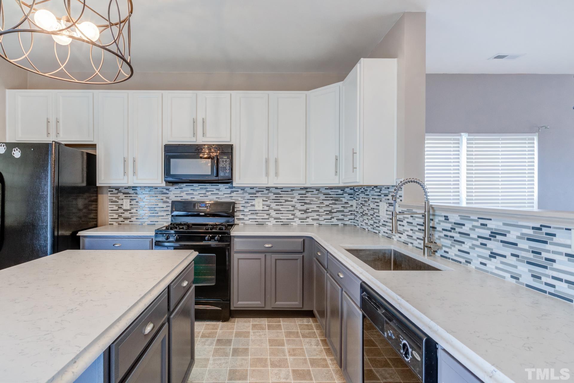 4911 Midstone Lane Raleigh, NC 27610 - Photo 9 of 28 a kitchen with a sink stove and refrigerator