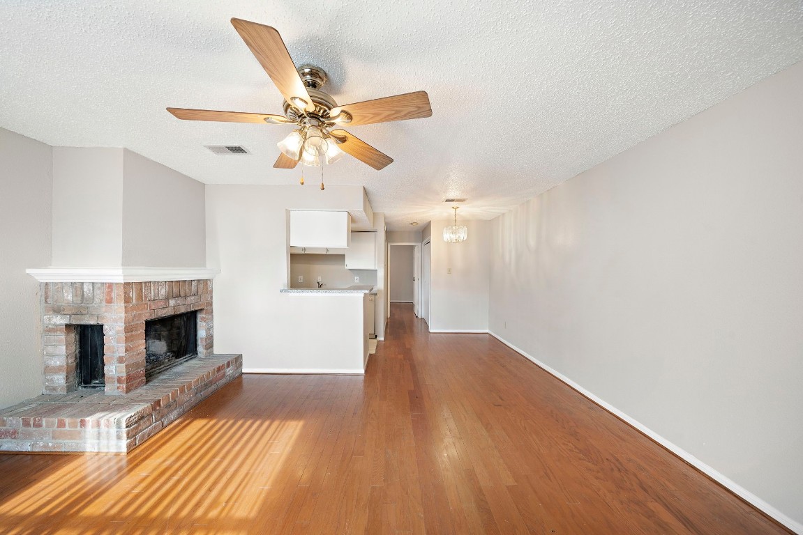 7402 Alabonson Road, Unit 506 Houston, TX 77088 - Photo 1 of 10 a view of a livingroom with a fireplace a ceiling fan and wooden floor