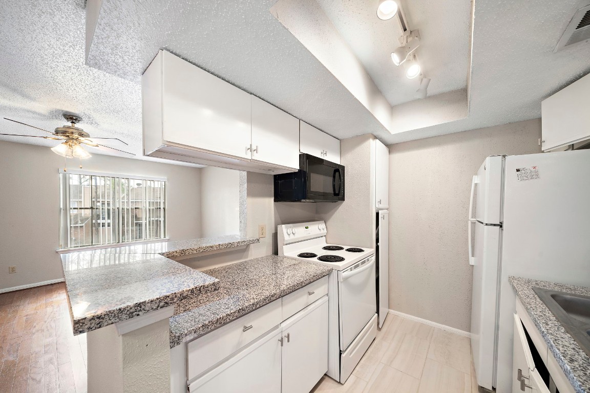 7402 Alabonson Road, Unit 506 Houston, TX 77088 - Photo 5 of 10 a kitchen with granite countertop a sink appliances and cabinets