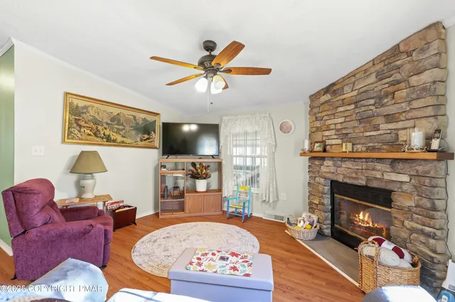 a living room with furniture a flat screen tv and a fireplace