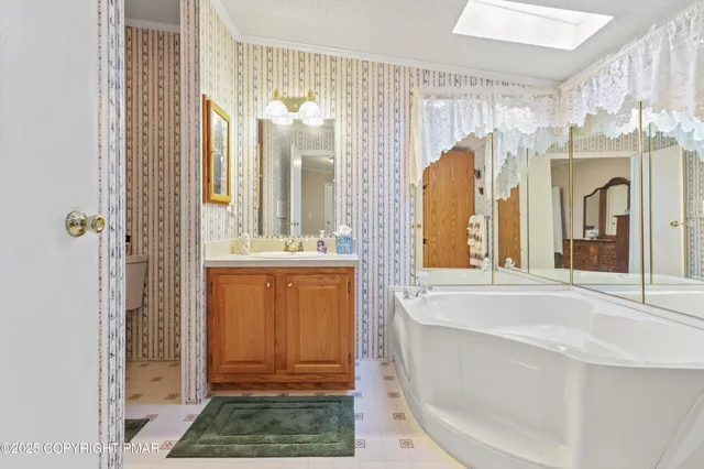 a bathroom with a tub a mirror and a shower